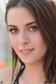 A beautiful young woman with long brown hair posing for a picture.