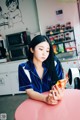 A woman sitting at a pink table eating a snack.